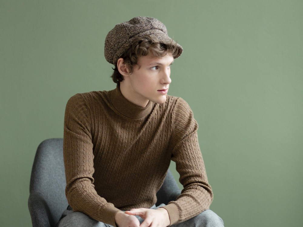 portrait-young-man-with-hat-sitting-chair